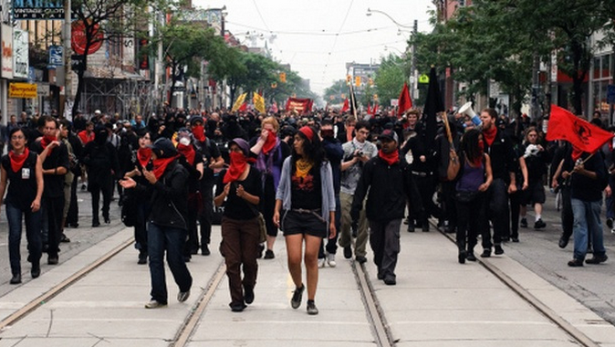 Harjap Grewal & Harsha Walia providing cover for the Black Bloc during the G20