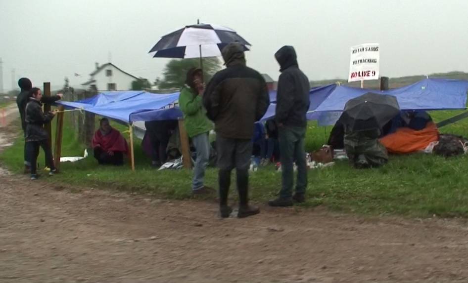 Anarchists huddled under a tarp made of oil