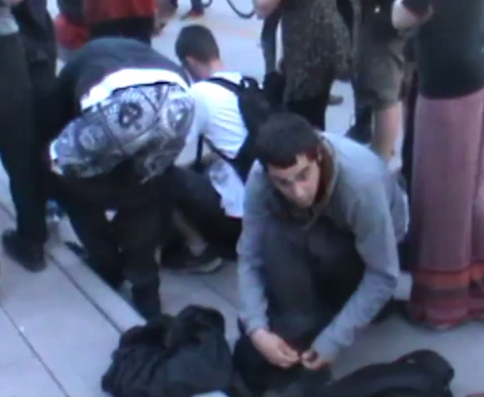 Black Bloc anarchist taking off his ninja costume