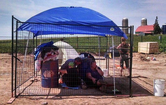 Dave Vasey, Wolfgang Chapkro & Trish Mills inside a self-constructed cage