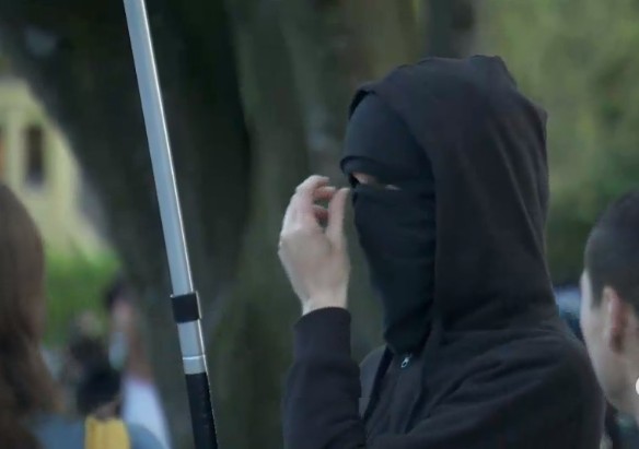 Masked thug carrying International Workers of the World flag at Grandview Park